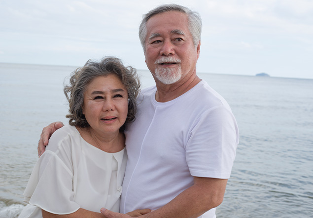 About-002 Portrait of happy Asian senior couple embracing together at the beach